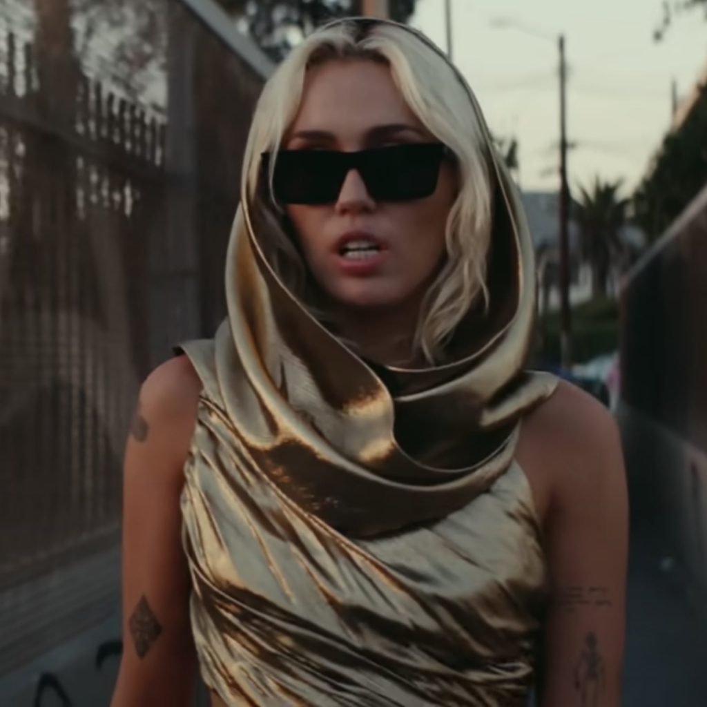 Picture of: Miley Cyrus Wears Gold Cutout Dress in “Flowers” Music Video